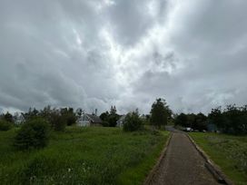 A pathway leading to houses with cloudy sky at 30 River Run in Belturbet