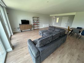 A living room with a sofa and television stand at 30 River Run in Belturbet, County Cavan