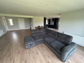 A living room with a sofa and dining area at 30 River Run, Belturbet, County Cavan