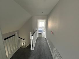 A hallway with a staircase and door at 30 River Run in Belturbet, County Cavan