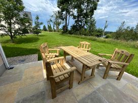 A patio with a wooden table and chairs at 30 River Run in Belturbet, County Cavan