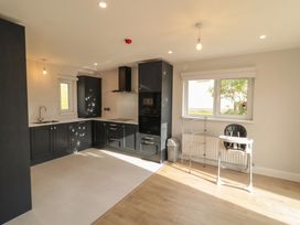 A kitchen with cabinets, sink, and a high chair at 30 River Run, Belturbet, County Cavan