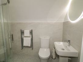 A bathroom with a shower, toilet, and sink at 30 River Run, Belturbet, County Cavan