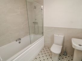 A bathroom with a bath tub, toilet, and sink at 30 River Run, Belturbet, County Cavan