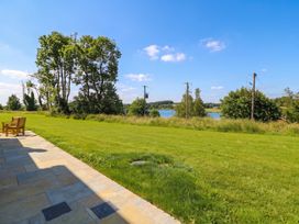 An outdoor area with a chair facing a lake at 30 River Run, Belturbet, County Cavan