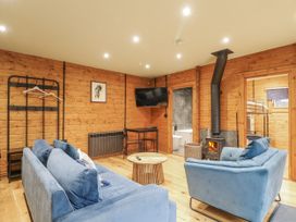 A living room with a sofa, armchair, and television at Otter's View South Luffenham near Edith Weston