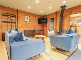 A snug with blue sofas and a wood stove at Otter's View in South Luffenham near Edith Weston