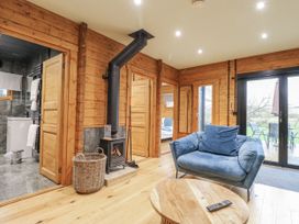 A living room with a wood stove and couch at Otter's View in South Luffenham near Edith Weston