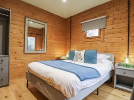 A bedroom with a bed and nightstand at Otter's View in South Luffenham near Edith Weston