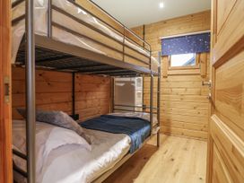 A bedroom with a bunk bed and wooden walls at Otter's View South Luffenham near Edith Weston