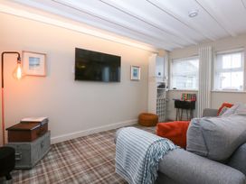 A living room with a television and sofa at Pine Cottage in Dinas Dinlle