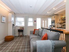 A living room with a couch and table at Pine Cottage in Dinas Dinlle