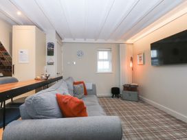 A living room with a sofa and television at Pine Cottage in Dinas Dinlle