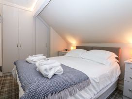 A bedroom with a bed and wardrobe at Pine Cottage in Dinas Dinlle