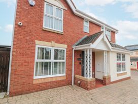 A red brick house with white framed windows and a small front porch at 48 Aysgarth Rise in Bridlington