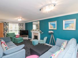 A living room with blue walls sofas armchair and a fireplace at 48 Aysgarth Rise in Bridlington