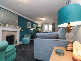 A living room with teal and gray furniture and a fireplace at 48 Aysgarth Rise in Bridlington