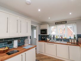 A kitchen with white cabinets wooden countertops a window with blinds and a sign saying kitchen disco at 48 Aysgarth Rise Bridlington