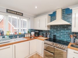 A kitchen with white cabinets wooden countertops blue tiled backsplash and stainless steel stove at 48 Aysgarth Rise Bridlington