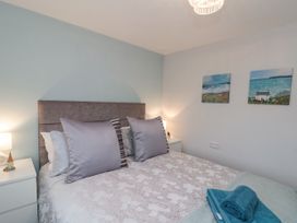A bedroom with a bed with pillows blankets and towels with two paintings on the wall at 48 Aysgarth Rise Bridlington