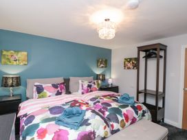 A bedroom with twin beds colorful bedding blue towel on beds blue accent wall and dark wood open wardrobe at 48 Aysgarth Rise in Bridlington