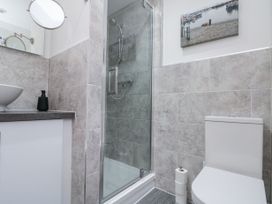 A bathroom with a shower enclosure a toilet a washbasin and a wall-mounted mirror at 48 Aysgarth Rise Bridlington