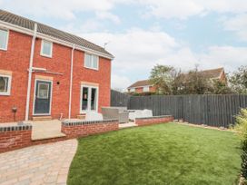 A backyard with a small patio and outdoor furniture next to a brick house at 48 Aysgarth Rise in Bridlington