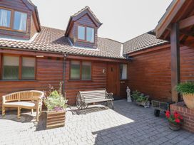An outdoor area with a bench and flower planters at Heron Cottage