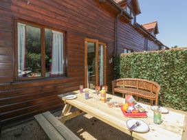 An outdoor dining area with a wooden table and chairs at Heron Cottage