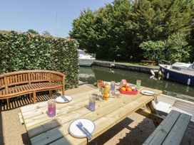 A picnic area with a table and boats by the water at Heron Cottage