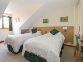 A bedroom with two single beds at Heron Cottage
