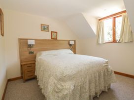 A bedroom with a double bed and window at Heron Cottage