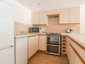 A kitchen with appliances and cabinets at Heron Cottage