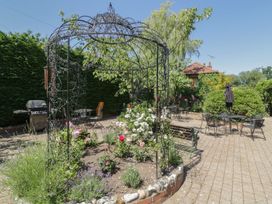 A garden with a decorative gazebo and outdoor seating at Heron Cottage 
