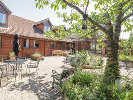 A garden with a table and chairs near a house at Heron Cottage