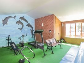 A gym with exercise equipment and a mural at Heron Cottage 