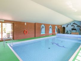 An indoor pool with a mural of dolphins at Heron Cottage 
