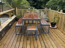 A table and benches on a wooden deck at Josie in Pentewan