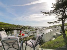 Outdoor patio with table and chairs overlooking holiday caravans and the sea at Ocean Pearl in Kingsbridge