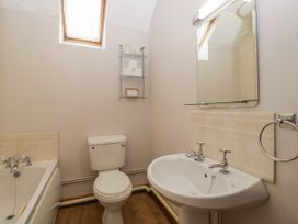 A bathroom with a bathtub toilet sink and a mirror at Anvil Cottage in Gatcombe near Blakeney