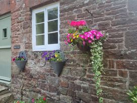 A stone wall with flowers in planters at Anvil Cottage near Blakeney