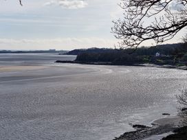 A coastal view with water and a distant house at Anvil Cottage in Gatcombe near Blakeney