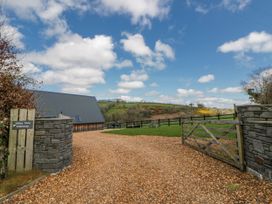 An outdoor view of a property entrance with a gravel driveway at Valley View Hideaway in Ffostrasol