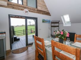 A dining room with a table set for meals at Valley View Hideaway in Ffostrasol
