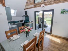 A kitchen with a dining table and chairs at Valley View Hideaway in Ffostrasol