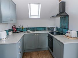 A kitchen with cabinets, sink, and appliances at Valley View Hideaway in Ffostrasol