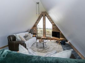 A living room with a coffee table and television at Valley View Hideaway in Ffostrasol
