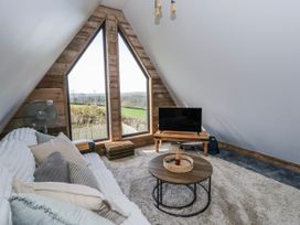 A living room with a television and sofa at Valley View Hideaway in Ffostrasol