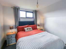 A bedroom with a bed and bedside table at Valley View Hideaway in Ffostrasol