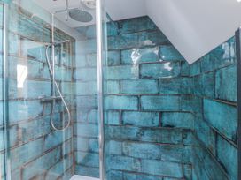 A shower with tiled walls at Valley View Hideaway Ffostrasol